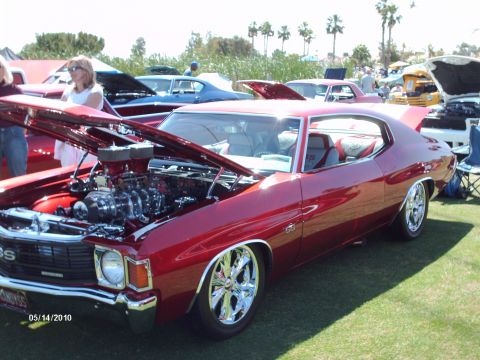1992 Ford Bronco - A red 1970 Chevrolet Chevelle SS is displayed at a car show with its hood open, revealing a custom engine.