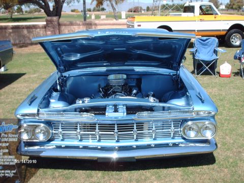 1992 Ford Bronco - Front view of a blue 1959 Chevrolet Impala at a car show, with a pickup truck in the background.