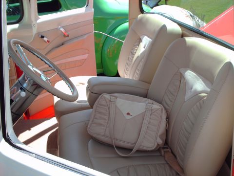 1992 Ford Bronco - Interior view of a car's tan seats and steering wheel, with other vehicles seen through the window.