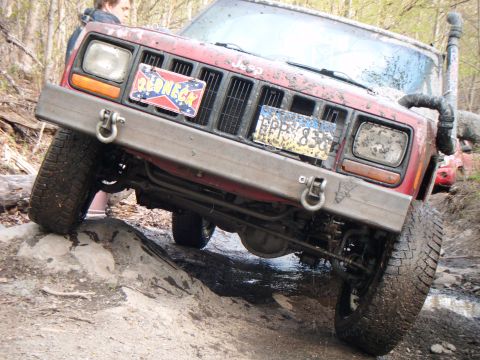1998 Jeep Cherokee - This red Jeep Cherokee is shown off-roading on a rocky trail, with a custom bumper and snorkel.