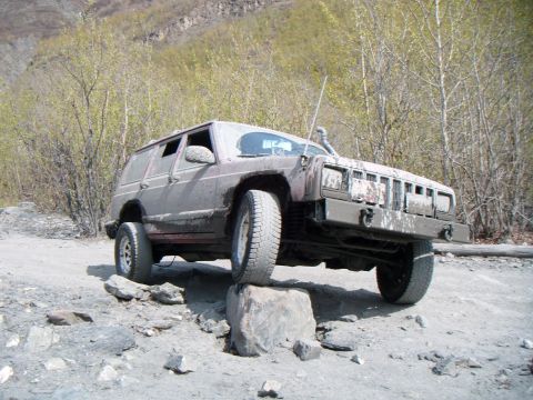 1998 Jeep Cherokee - This 1998 Jeep Cherokee is navigating a rocky trail, with one wheel on a large boulder.
