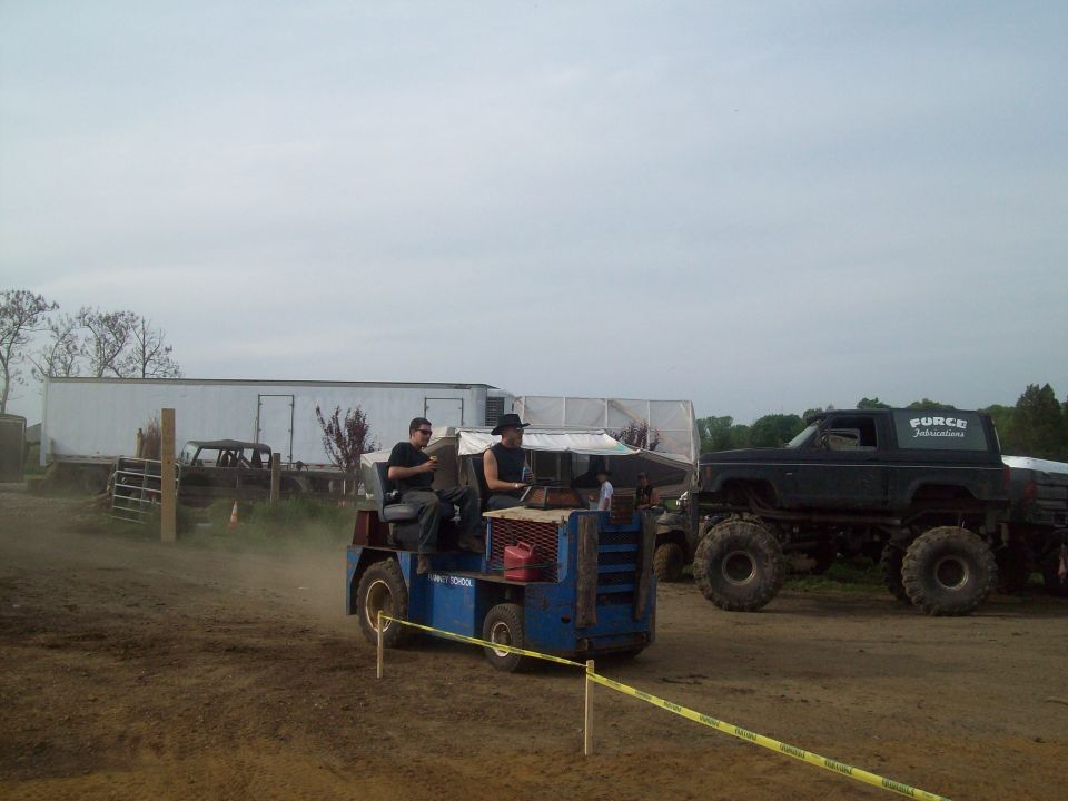 Monster truck with 'FORCE' on the side, and a blue utility vehicle with two people driving