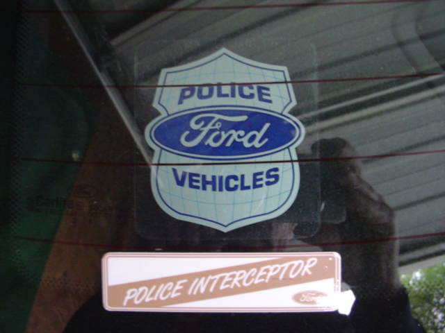 Ford Police Vehicles shield decal and Police Interceptor badge on a car's rear window