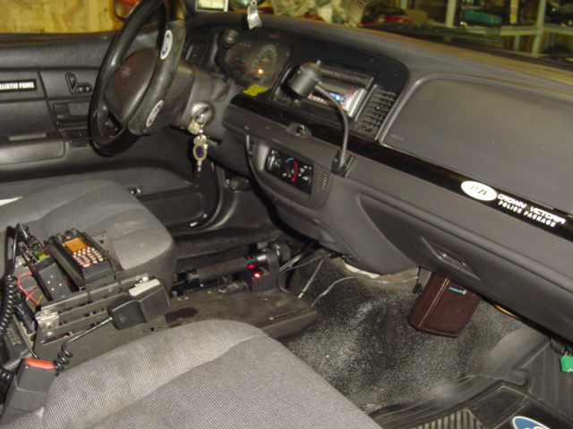 Interior of a 2003 Ford Crown Victoria police car with radios and equipment