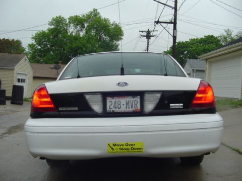 2003 Ford Crown Victoria - The rear of a white 2003 Ford Crown Victoria is shown, its license plate and a bumper sticker.