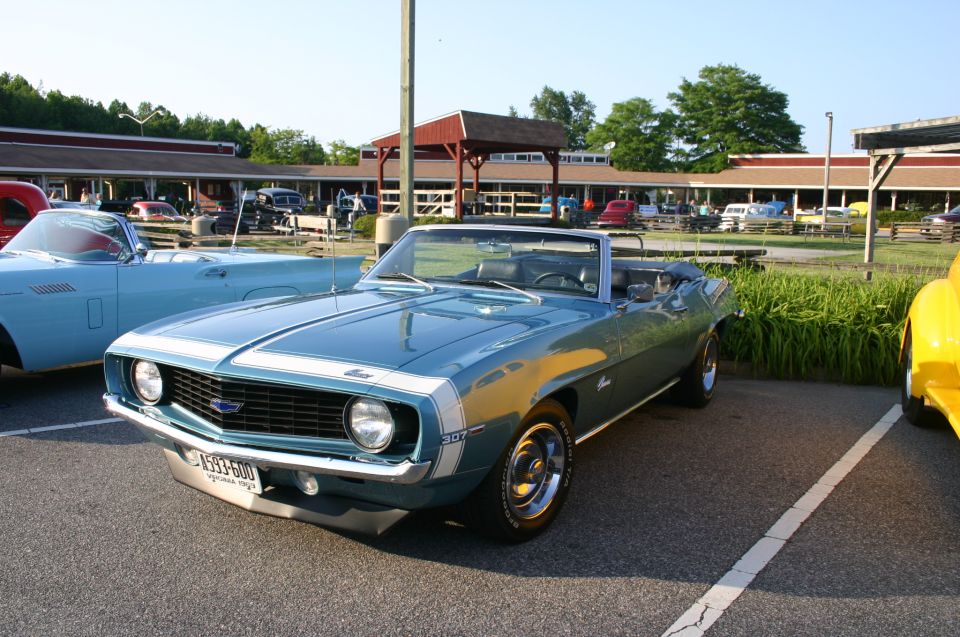 1969 Camaro convertible with white racing stripes and a blue grille emblem. License plate reads '1593-600'