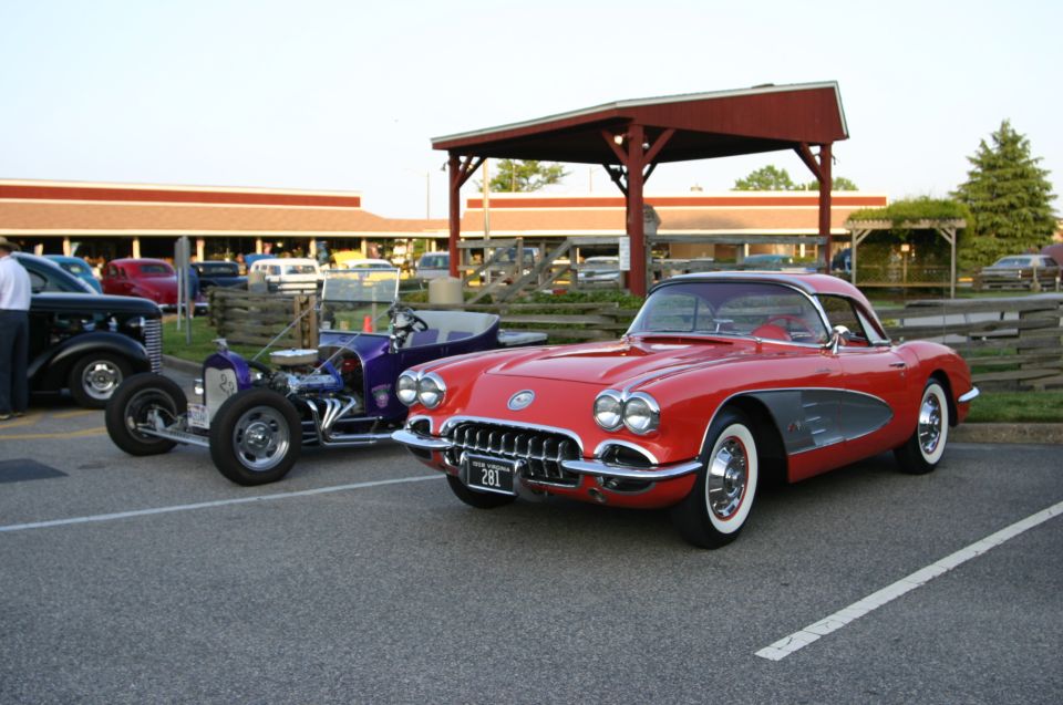 Red 1958 Chevrolet Corvette with a black roof and chrome trim parked in a lot