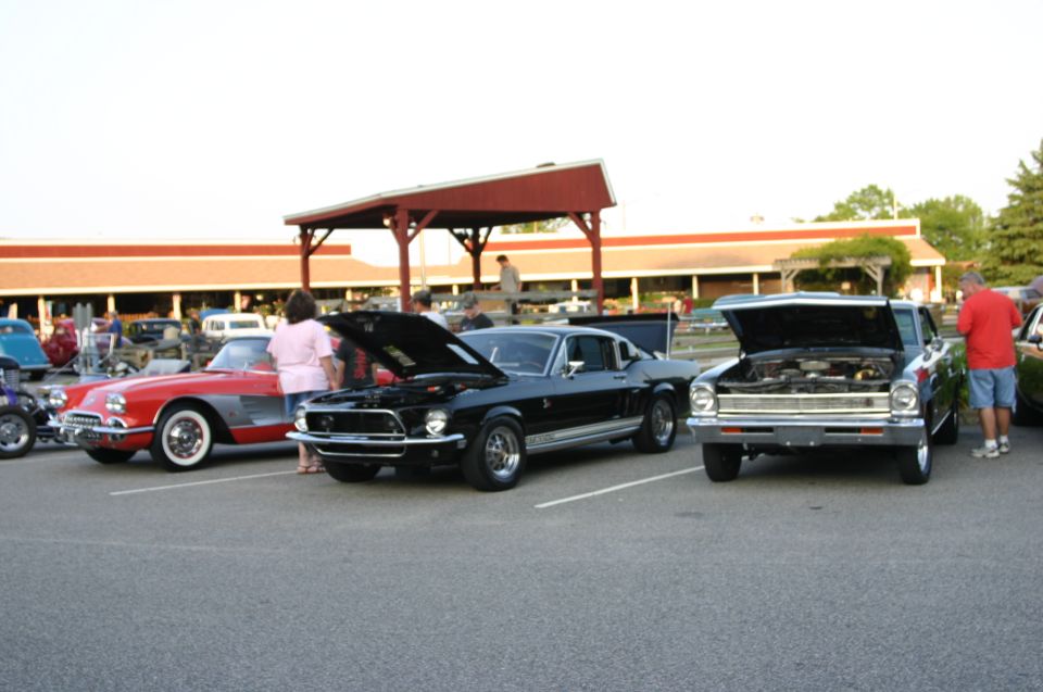 Black 1968 Ford Mustang GT500 with hood open, parked at a car show