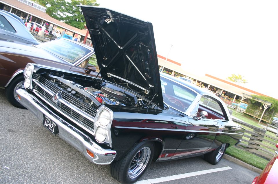 Black 1967 Ford Fairlane with hood open, parked next to a brown car