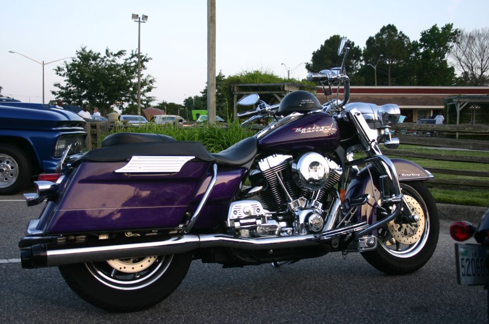 Purple Harley-Davidson motorcycle parked next to a blue pickup truck
