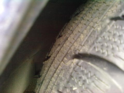1998 BMW 3 Series - A close-up view of a vehicle's tire and the surrounding wheel well area.