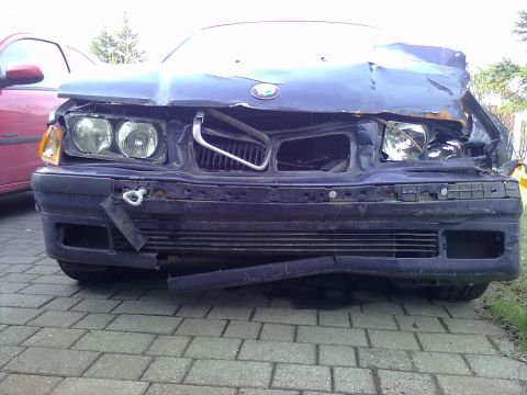 1998 BMW 3 Series - The front of a dark blue car shows significant damage to the hood, grille, and bumper area.