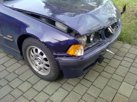 1998 BMW 3 Series - Front view of a damaged blue 1998 BMW 3 Series, with visible damage to the hood, bumper, and headlights.
