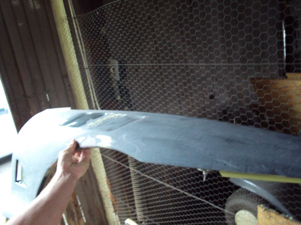 Gray car fender held by hand