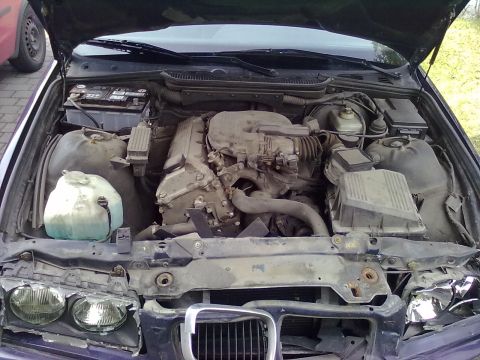 1998 BMW 3 Series - The engine bay of a 1998 BMW 3 Series, the engine and other components, with a Supermotors.net logo visible.
