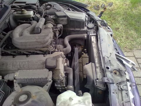 1998 BMW 3 Series - Close-up of a BMW engine bay, highlighting the motor, fan, and radiator assembly.