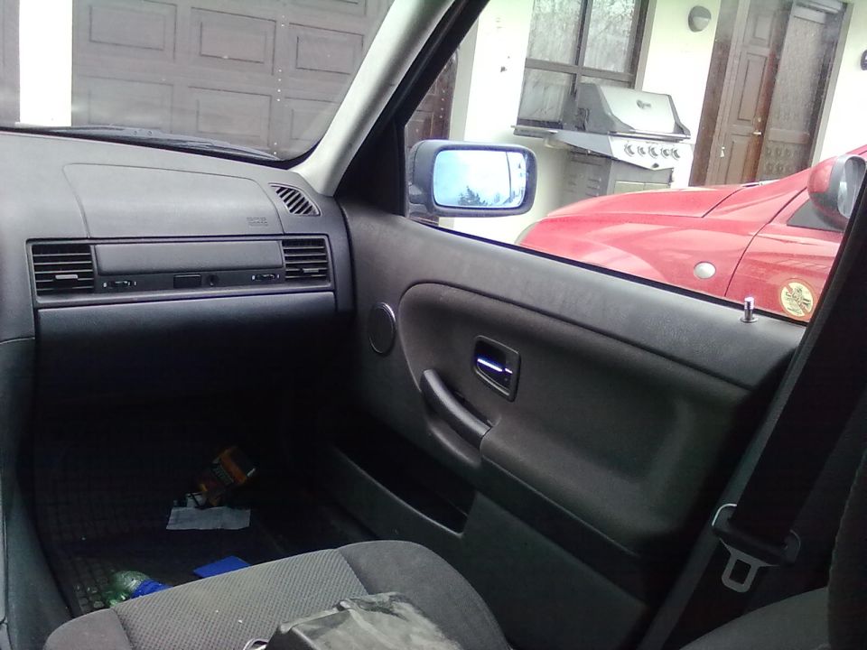Black passenger-side dashboard and door panel interior with grey cloth seat