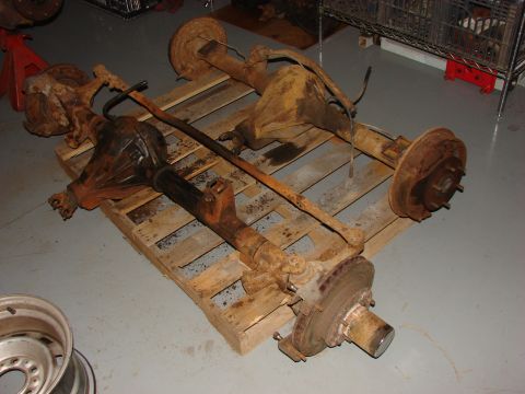 1993 Jeep YJ - Two vehicle axles, likely from an older 4x4, sit on a pallet in a workshop.