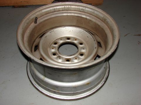 1993 Jeep YJ - A single silver wheel rim is shown from a slightly elevated angle, resting on a gray surface.