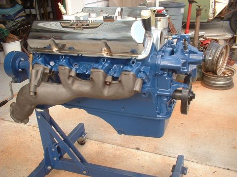 1969 Ford Torino - A Ford 427 engine, identified by the badge on the valve cover, is displayed on a blue engine stand.