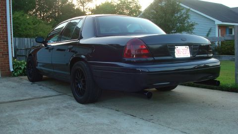 2004 Ford Crown Victoria - Rear view of a black 2004 Ford Crown Victoria with aftermarket wheels and exhaust.