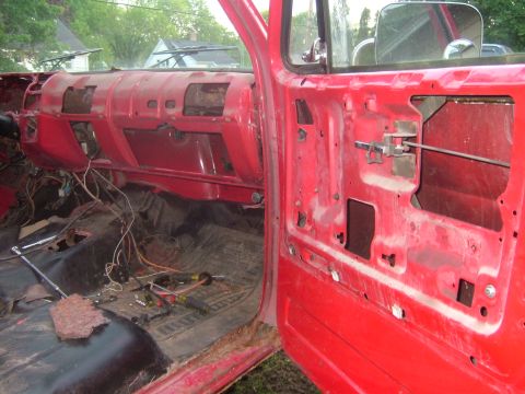 1985 Chevrolet C/K Pickup - Interior view of a 1985 Chevrolet C/K Pickup, showing the dashboard and door panel removed, revealing wiring and internal components.