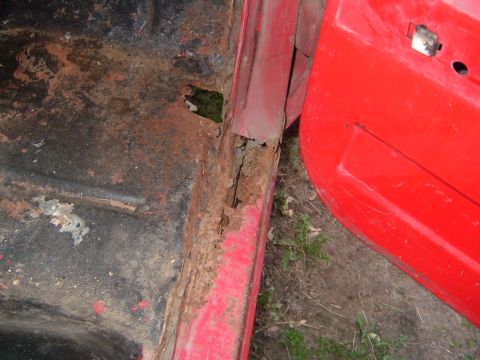 1985 Chevrolet C/K Pickup - The door sill and floor pan of this vehicle are heavily rusted, showing significant deterioration.