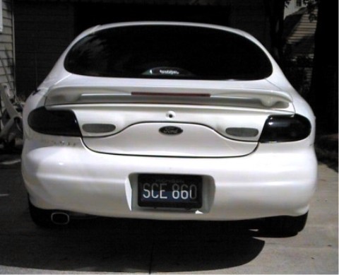 1997 Ford Taurus - Rear view of a white 1997 Ford Taurus with a spoiler and tinted taillights.