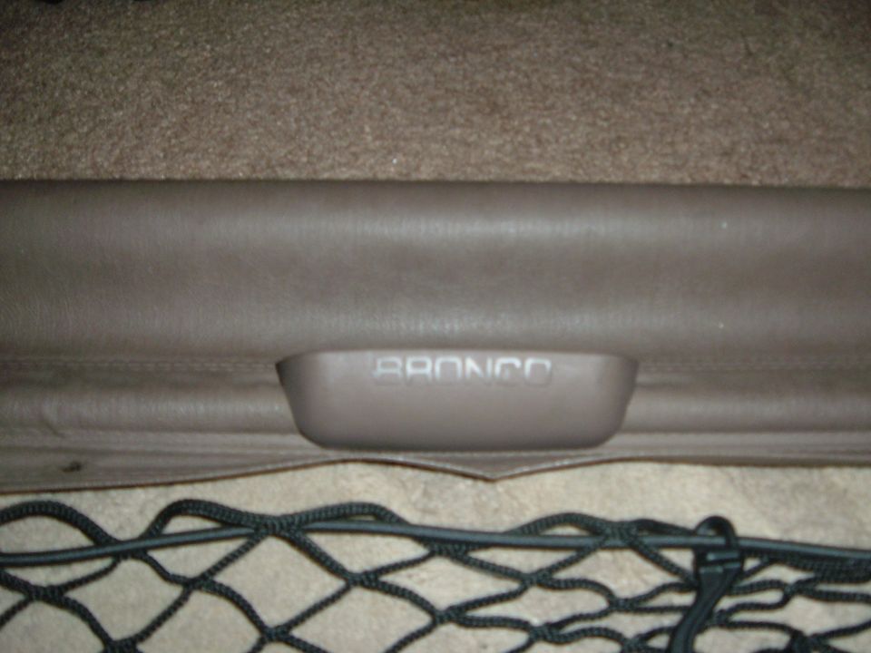 Tan cargo cover pull handle embossed BRONCO on the vinyl leading edge