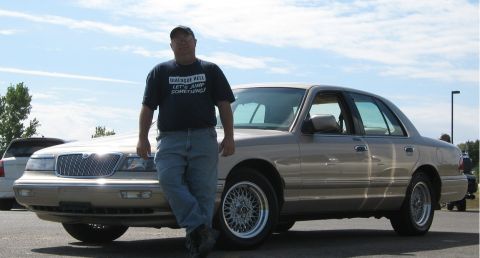 2000 Mercury Grand Marquis - A man poses with a tan 2000 Mercury Grand Marquis sedan at a car meet.