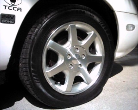 1997 Ford Taurus - Close-up of a 1997 Ford Taurus wheel and the '24V DOHC' emblem on the fender.