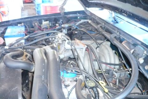 1992 Ford Bronco - The engine bay of a vehicle is shown, with various mechanical parts and wiring.