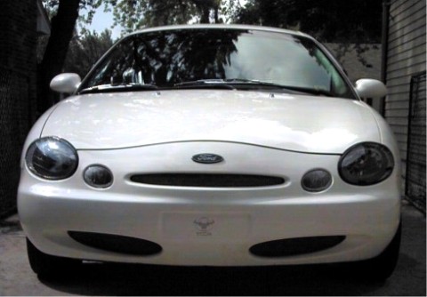 1997 Ford Taurus - This white Ford sedan has a distinctive front end with oval headlights and a curved grille.