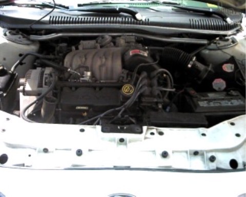 1997 Ford Taurus - Engine bay of a 1997 Ford Taurus, showing the alternator, intake manifold, and battery.
