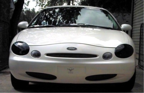 1997 Ford Taurus - Front view of a white 1997 Ford Taurus, showing its distinctive oval grille and headlights.