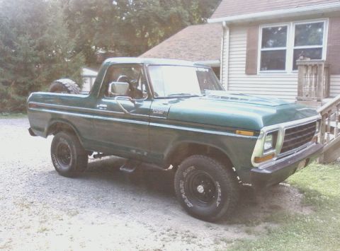 1979 Ford Bronco - This green Ford Bronco is parked in front of a house with a gravel driveway and a wooden porch.