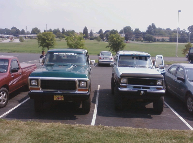 Green 1979 Ford F-Series truck parked next to a light blue Ford Bronco, front view