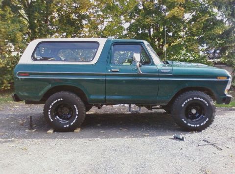 1979 Ford Bronco - A green and white 1979 Ford Bronco is parked outdoors on a gravel surface.