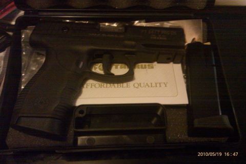 2000 Mercury Grand Marquis - A black Taurus pistol is displayed in its case alongside a magazine and instruction manual.