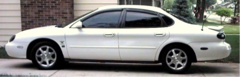 1997 Ford Taurus - This 1997 Ford Taurus is seen from the side, parked in front of a brick house.