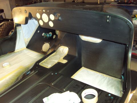 1948 Jeep Wrangler - The interior of a Jeep is shown with the floor and dashboard area prepared for painting, indicating ongoing restoration work.