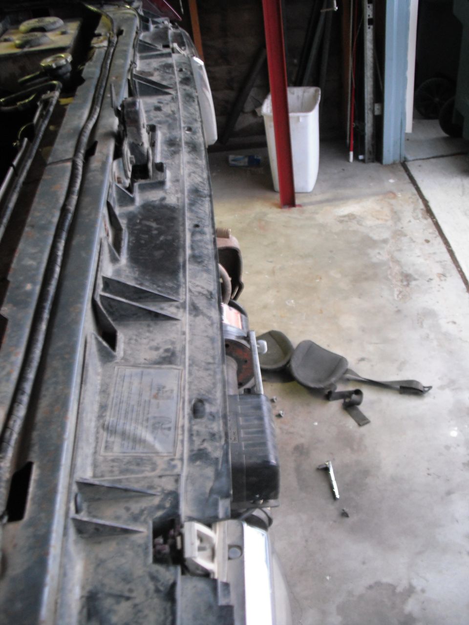Close-up of a black plastic radiator support bracket with some text visible
