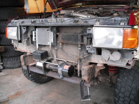 1991 Ford Bronco - The front of a vehicle is disassembled, revealing the radiator, winch, and other components.