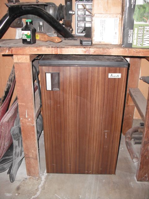 1991 Ford Bronco - A woodgrain-finished Avanti mini-fridge sits under a workbench.