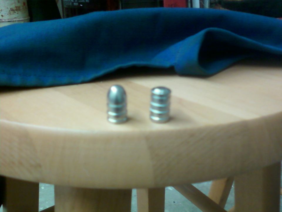 two bullets on a wooden table with a blue cloth in the background