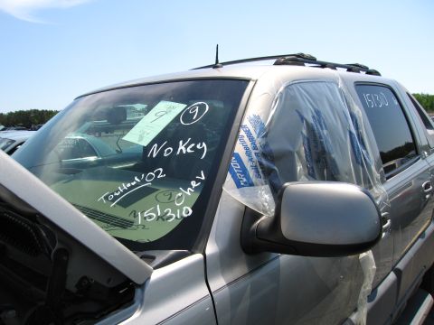 1991 Ford LTD Crown Victoria - A silver Chevrolet Avalanche has 'No Key' and 'Tout haut '02' written on the windshield, with '151310' on the door.