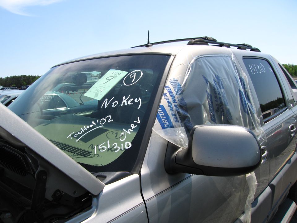 Silver Chevrolet Avalanche with 'No Key' and 'Tout haut '02' written on windshield. '151310' on door