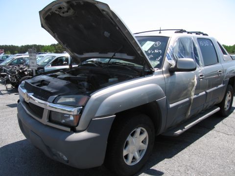 1991 Ford LTD Crown Victoria - A silver SUV sits in a lot with its hood open, showing the engine compartment.