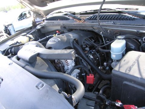 1991 Ford LTD Crown Victoria - Close-up view of a VORTEC engine bay, showing the engine cover and electrical center. Another vehicle is partially visible in the backgroun…