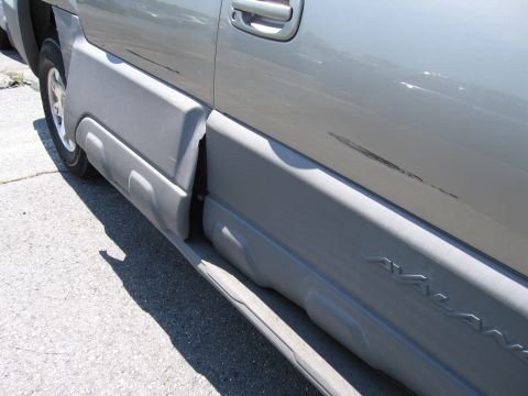 1991 Ford LTD Crown Victoria - The side of a Chevrolet Avalanche with visible scratches on the paintwork.